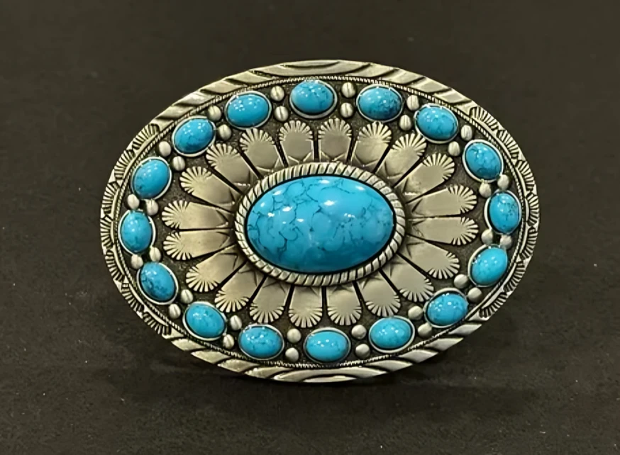 A turquoise belt buckle with details.