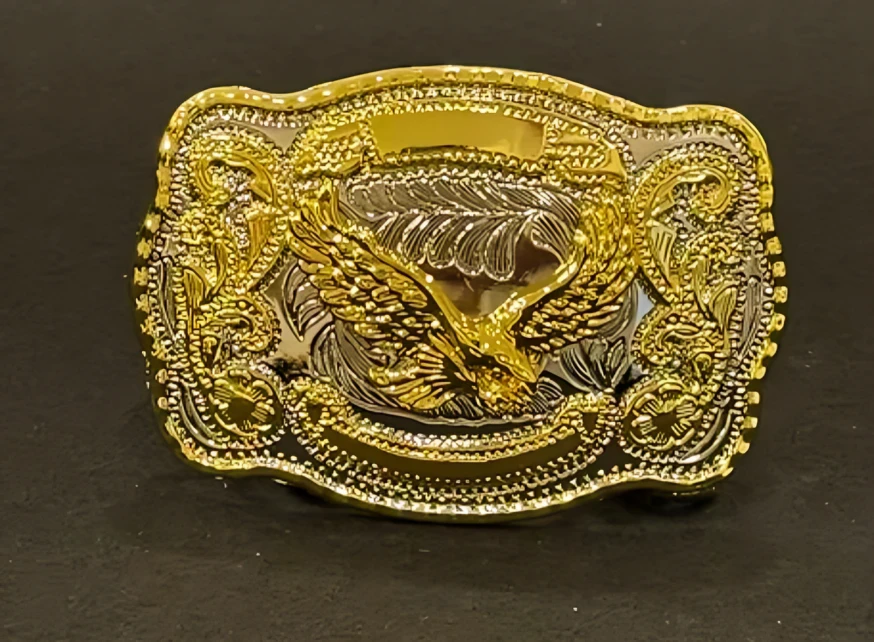 A golden cowboy buckle with an eagle