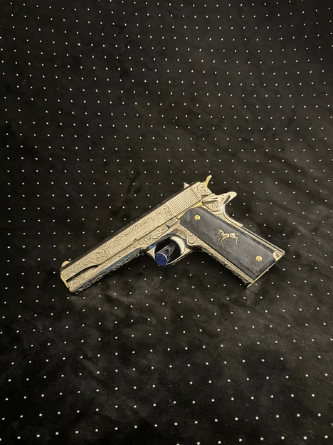 Colt .45 ACP featuring engraved metalwork and blue custom grips