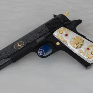 Engraved Colt custom firearm with black and gold detailing and white grips inlaid with golden eagle design.