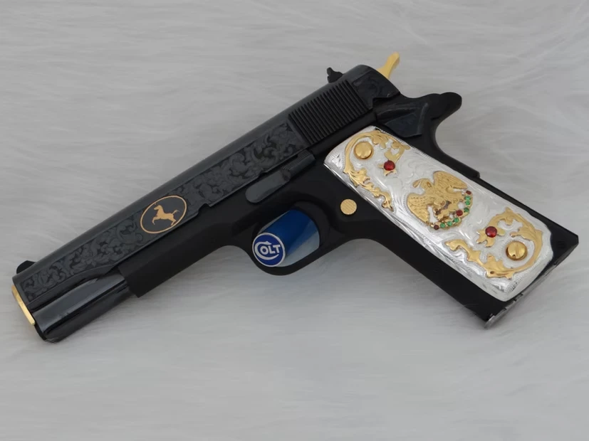 Engraved Colt custom firearm with black and gold detailing and white grips inlaid with golden eagle design.