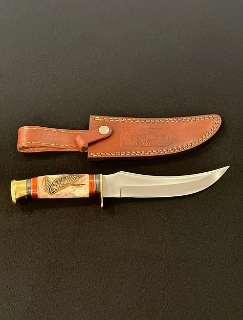 A Bowie knife with various details on the grip.