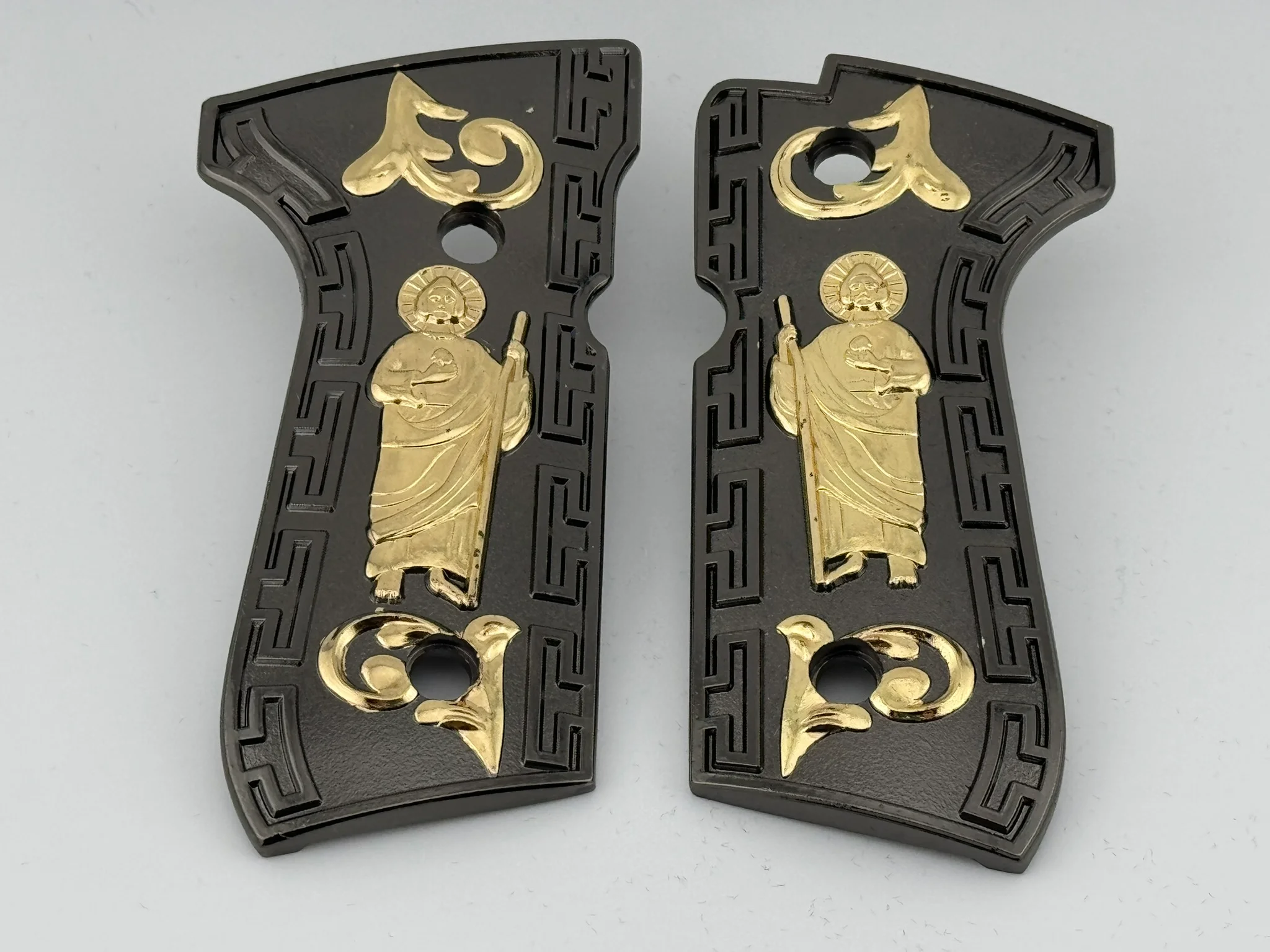 Gun grips with a holy figure depicted in gold 