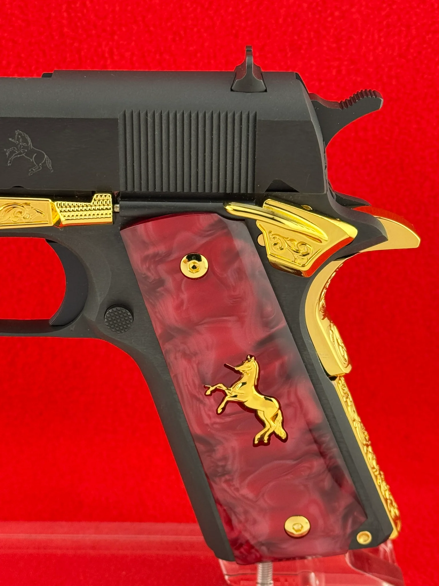 A handgun grip featuring intricate custom gold engraving on the handle