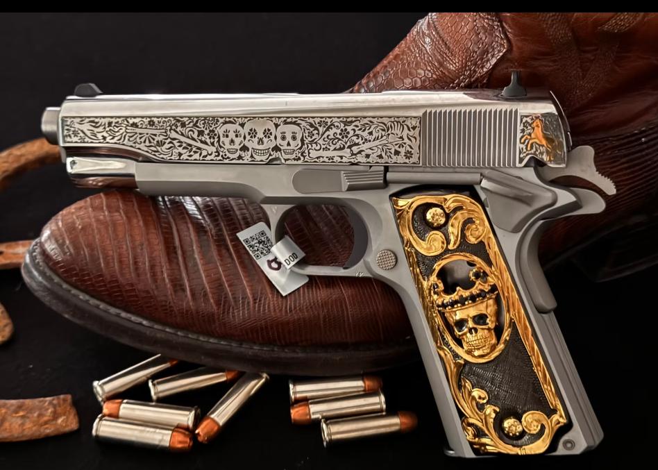 Firearm with skull engraving and gold inlay on grips displayed with leather boots and bullets.