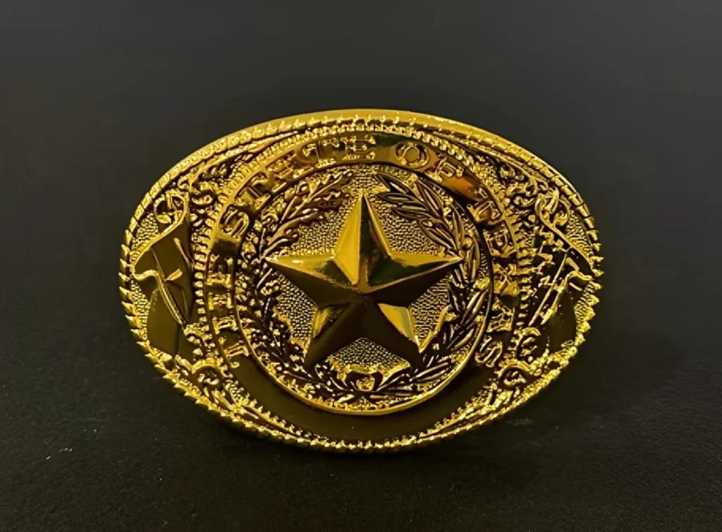 A gold belt buckle with a star.