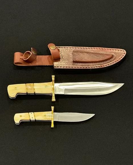 A knife with a gold blade and brown sheath