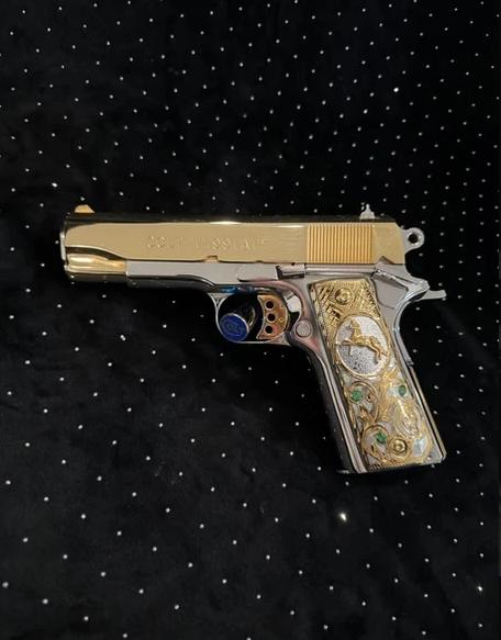 A silver and gold embellished gun