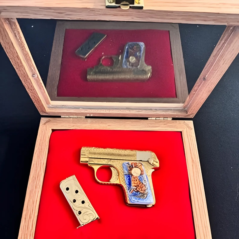 Custom firearm with gold plating displayed inside a premium gun display case